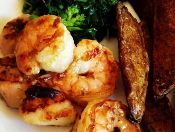 Camarones y vieiras a la parrilla con mantequilla al pesto con ajo